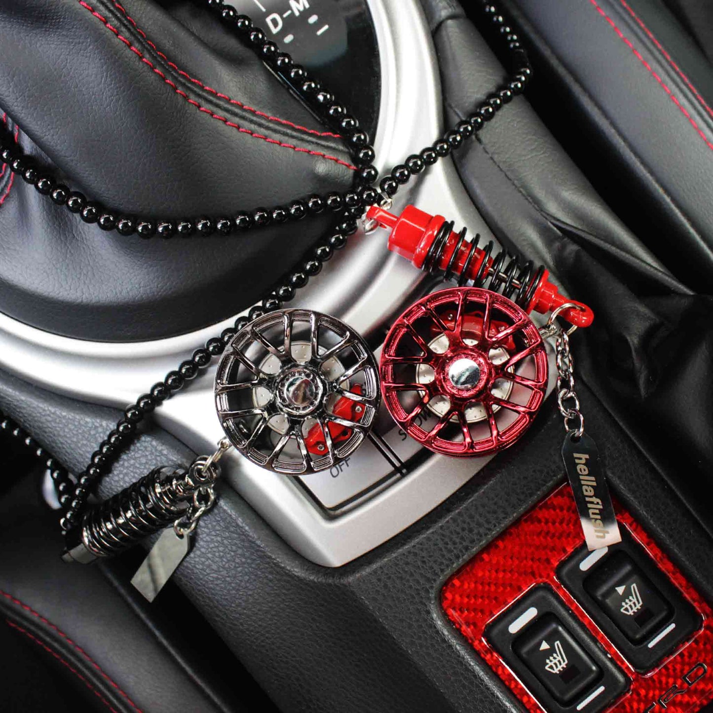 Two wheel decors placed on a car's centre console, one is black and one is red