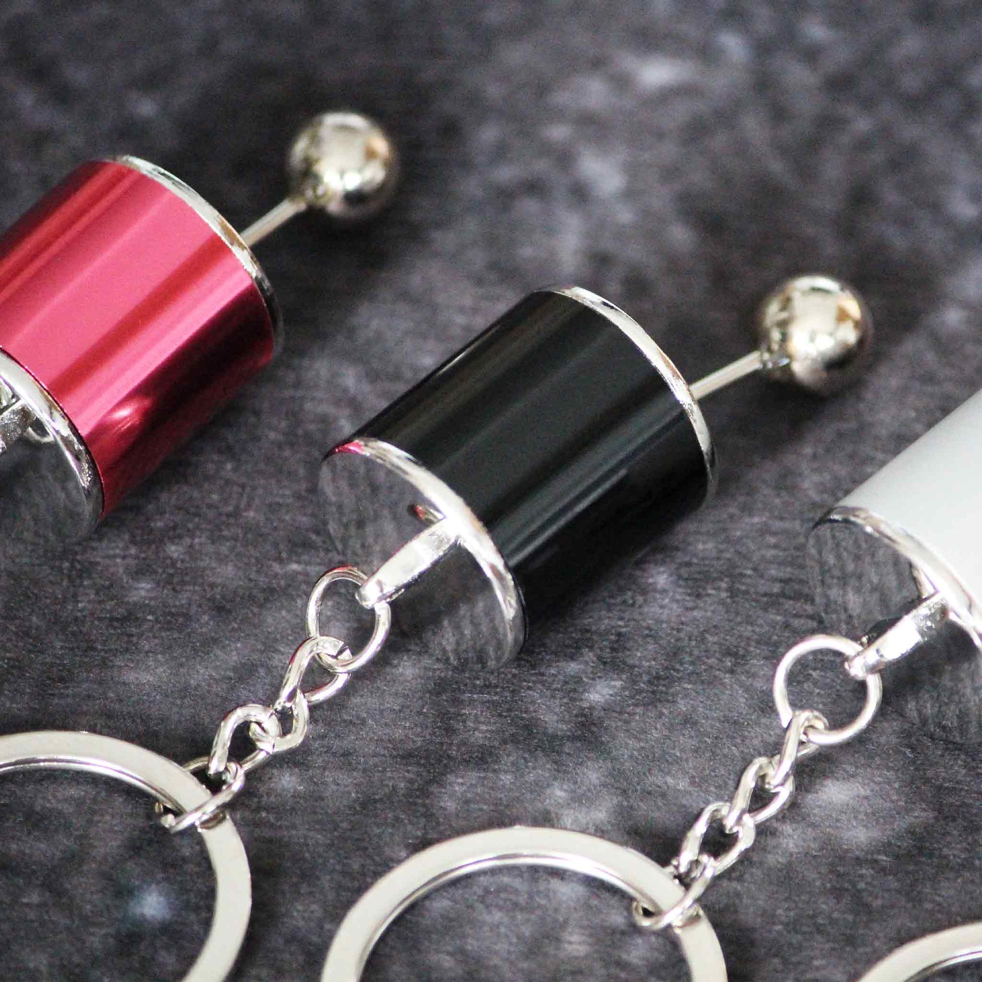 Close-up of a black turbo keychains with red and grey on both sides