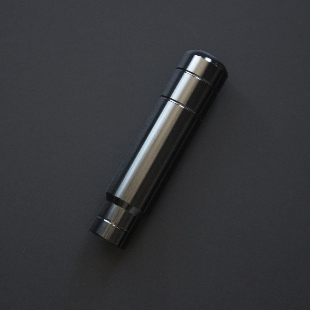 A black aftermarket shift knob flat laid on a black background