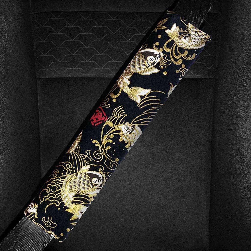 A black koi fish seat belt pad is installed in a car