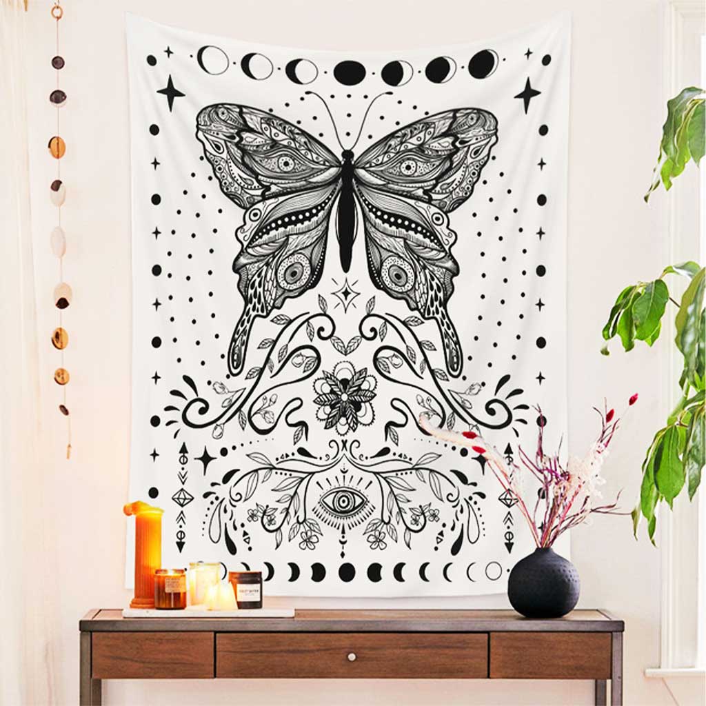 A wall poster featuring a beautiful butterfly hung on a white wall, and there are some candles and a vase on the wooden table underneath the poster