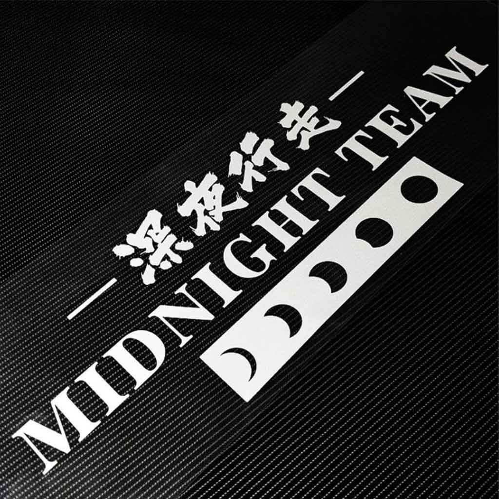 A Midnight Team car vinyl decal is placed on a black carpet