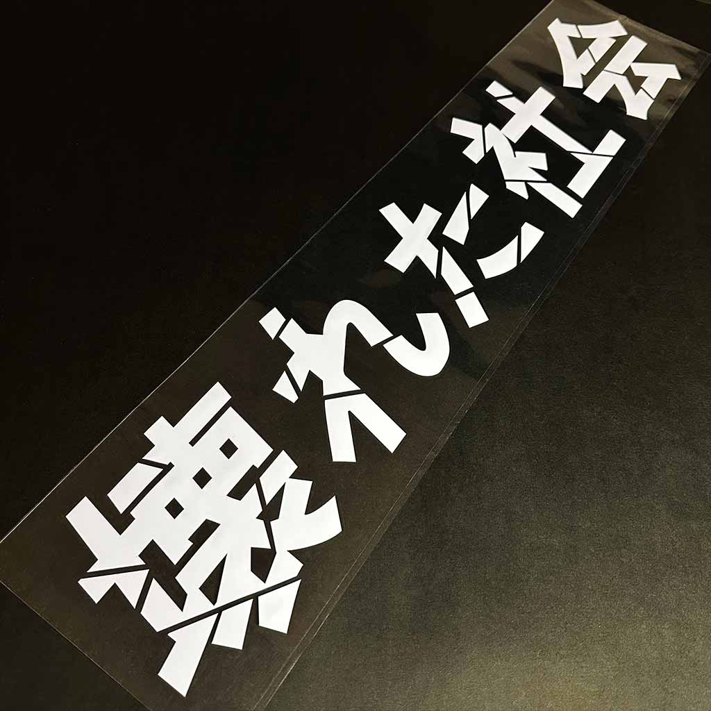 A Broken Society car vinyl decal is placed on a black background