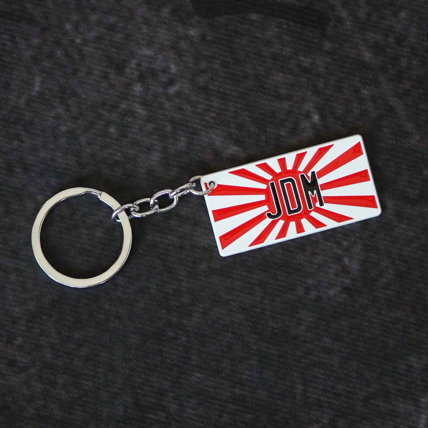 A flat lay JDM keychain on a dark grey background