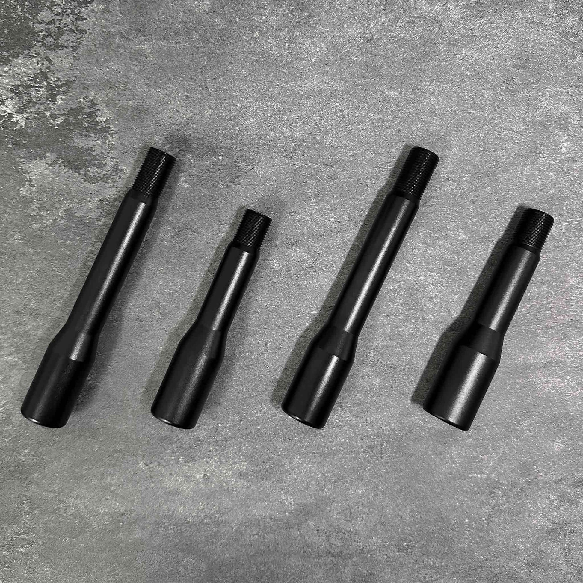 Four shift knob extensions in two different sizes are placed neatly on a grey background