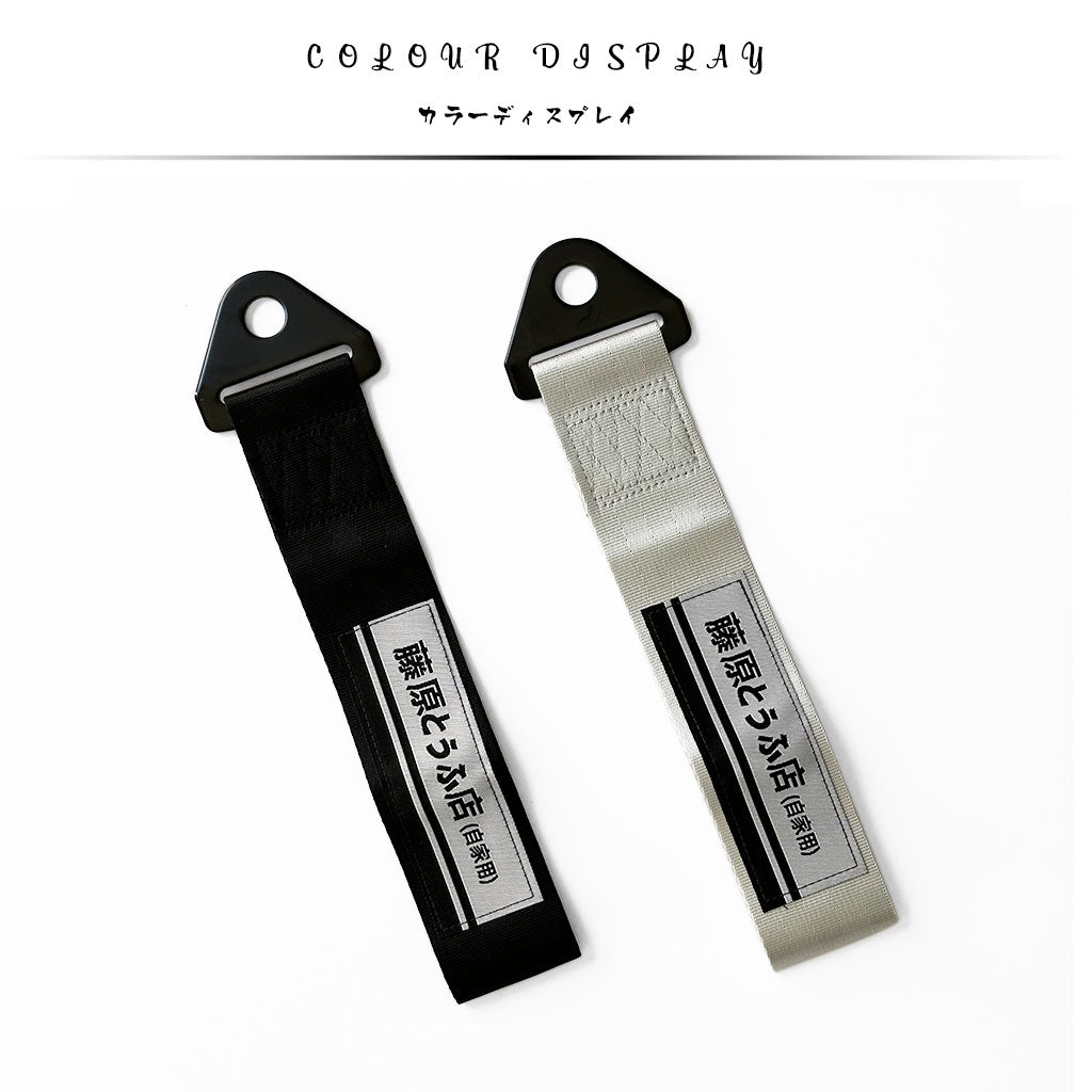 A black and a silver JDM tow strap with 'Fujiwara Tofu Shop' characters flat laid on a white background