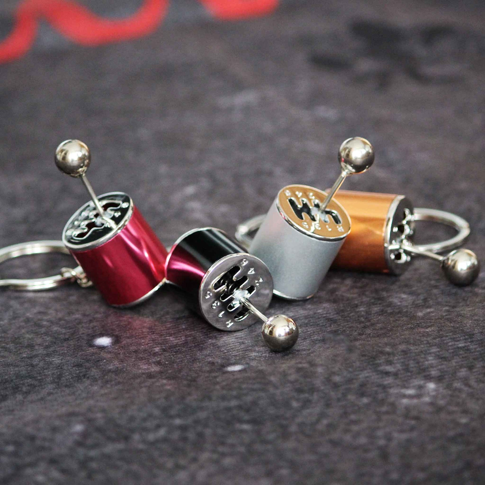 Four turbo keychains with different colours placed aesthetically on a grey fabric