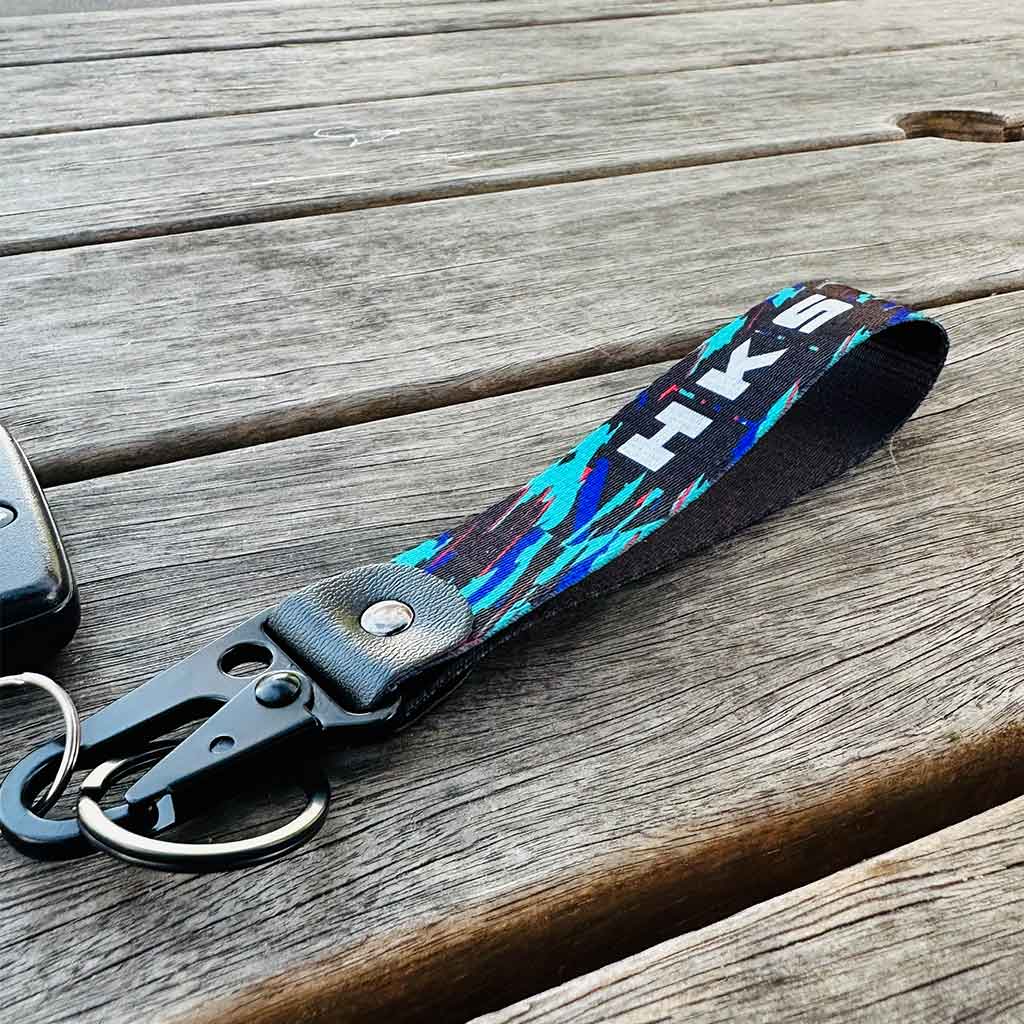 A HKS lanyard on a rustic wooden bench