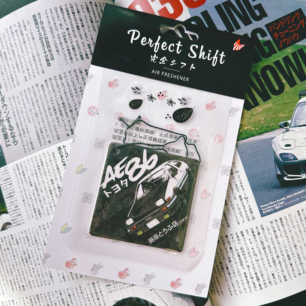 A JDM car air freshener themed panda AE86 flat laid on a Japanese magazine