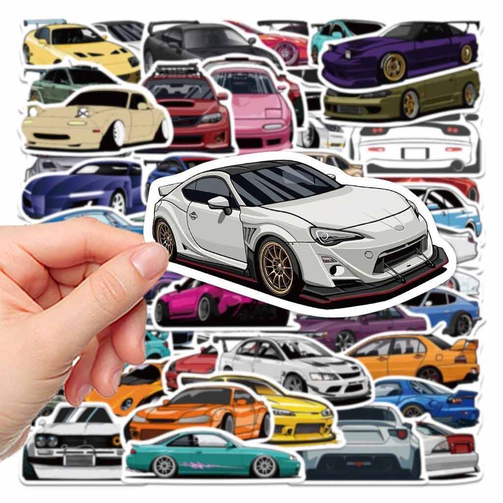 Hand holding a toyota gt86 sticker with lots of different car stickers at background