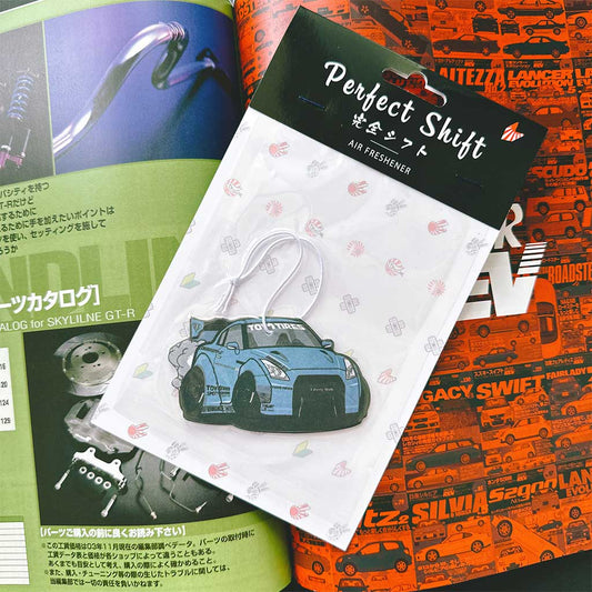 A JDM car air freshener themed GTR35 Toyo Tires flat laid on a Japanese magazine
