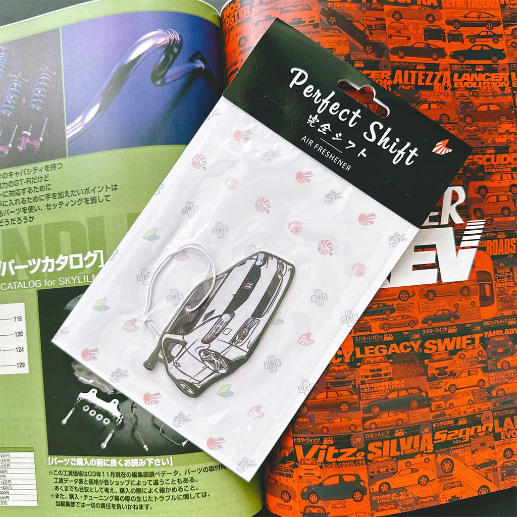 A JDM car air freshener themed Honda Type R flat laid on a Japanese magazine