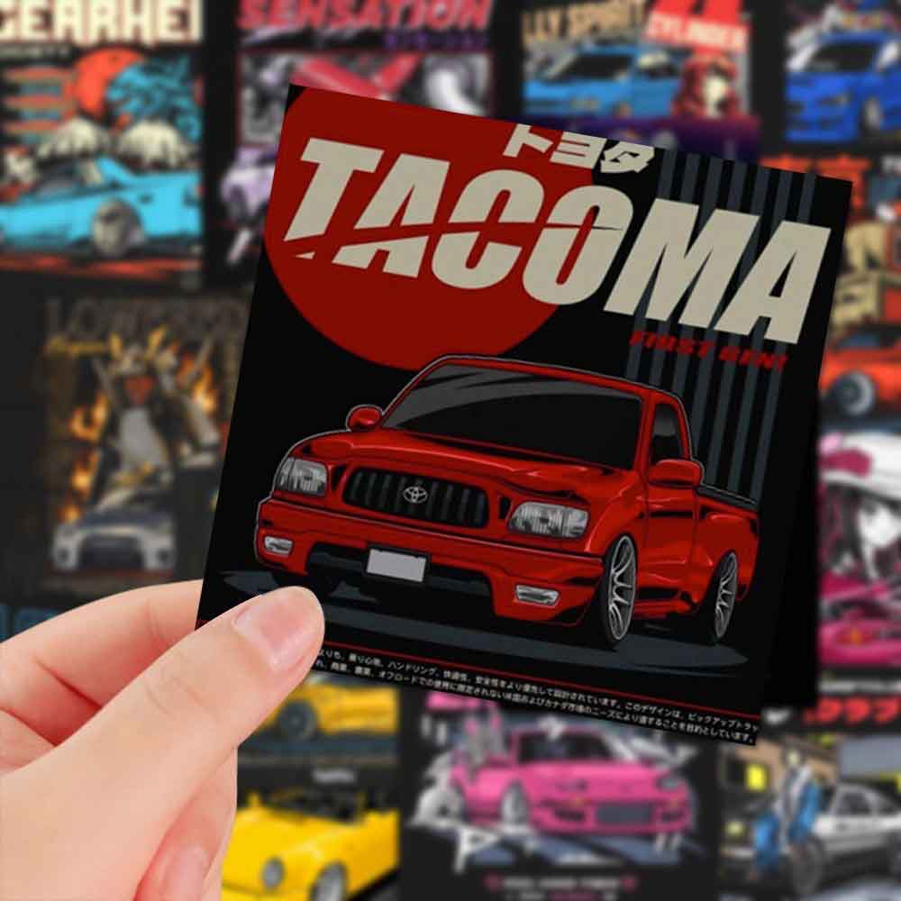 A hand holding a Toyota vintage truck mini sticker in front of assorted JDM mini stickers