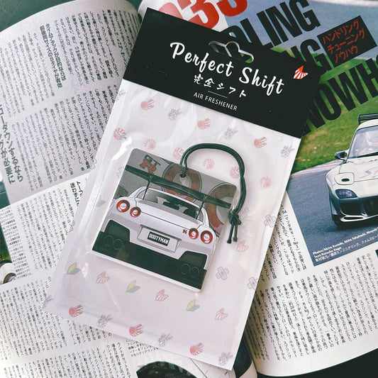 A JDM car air freshener themed Nissan Skyline GTR35 flat laid on a Japanese magazine