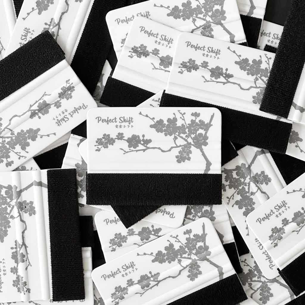 Several JDM banner sticker application squeegees with cherry blossom pattern and Perfect Shift logo on a white background