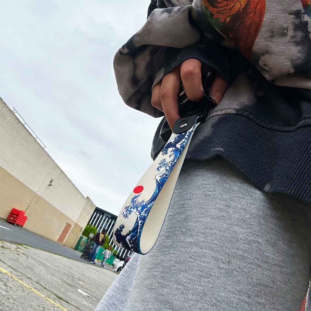 A great wave lanyard held by a hand in an open area