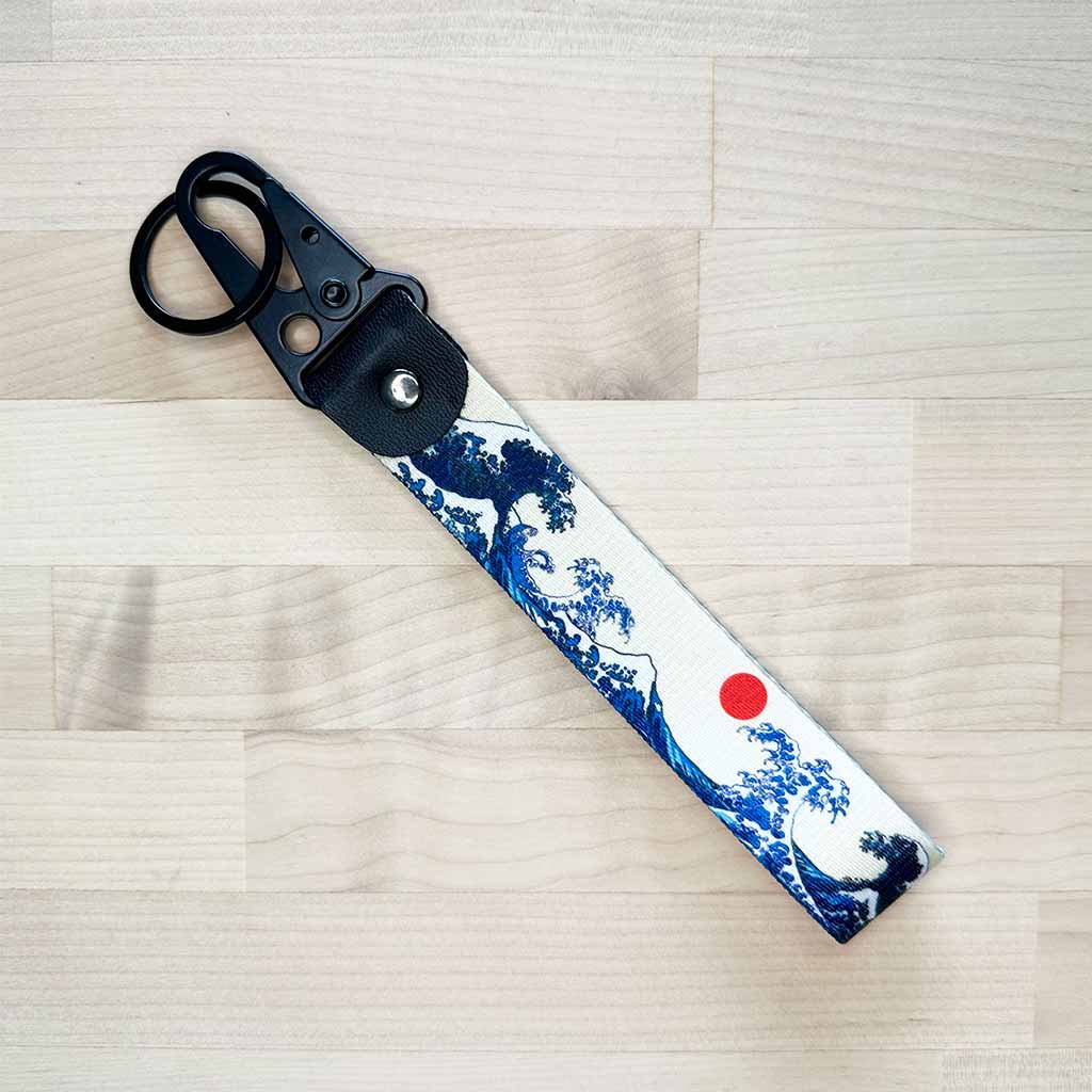 A flat lay great wave lanyard on a light-coloured wooden table