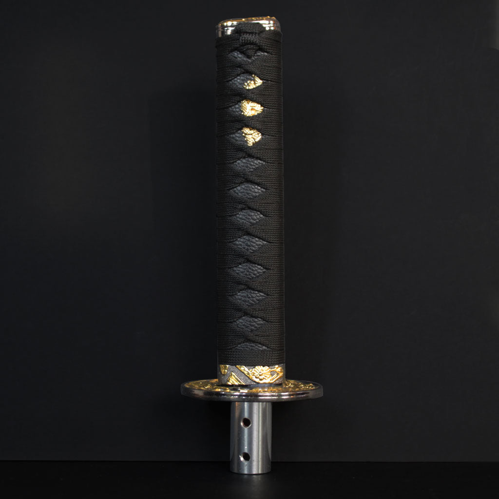 An all-black Katana shift knob standing in front of a black wall