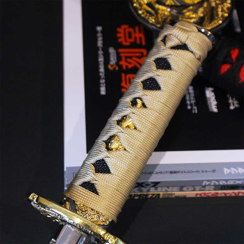 Close-up of a gold katana shifter with a Japanese JDM magazine underneath