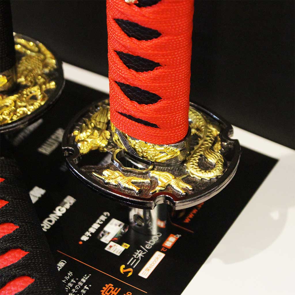 Close-up of the engraves on the sword guard of a red katana shifter