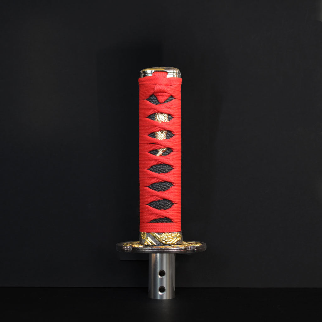 A red Katana shift knob standing in front of a black wall
