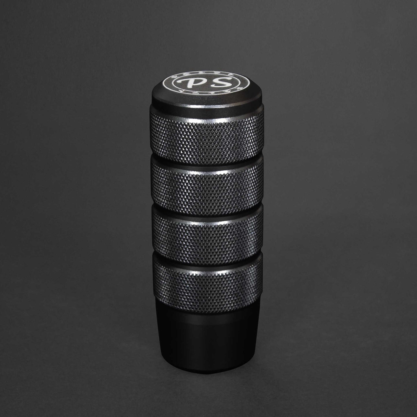 A black shift knob standing on a black background