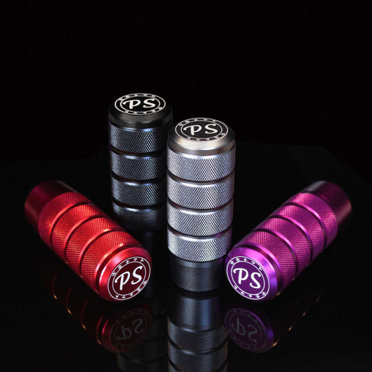 Four shift knobs in different colours aesthetically stand on a mirror