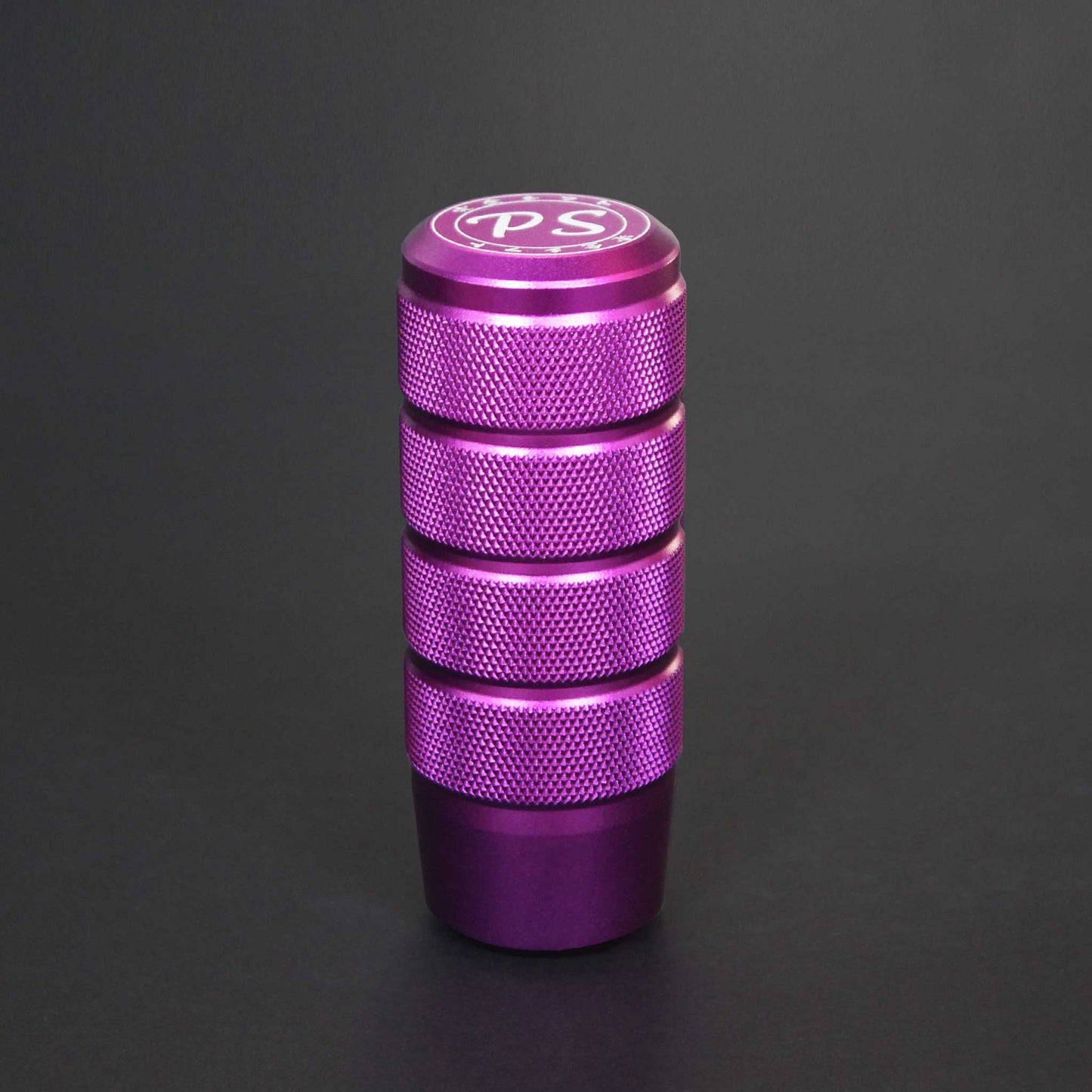 A purple shift knob standing on a black background
