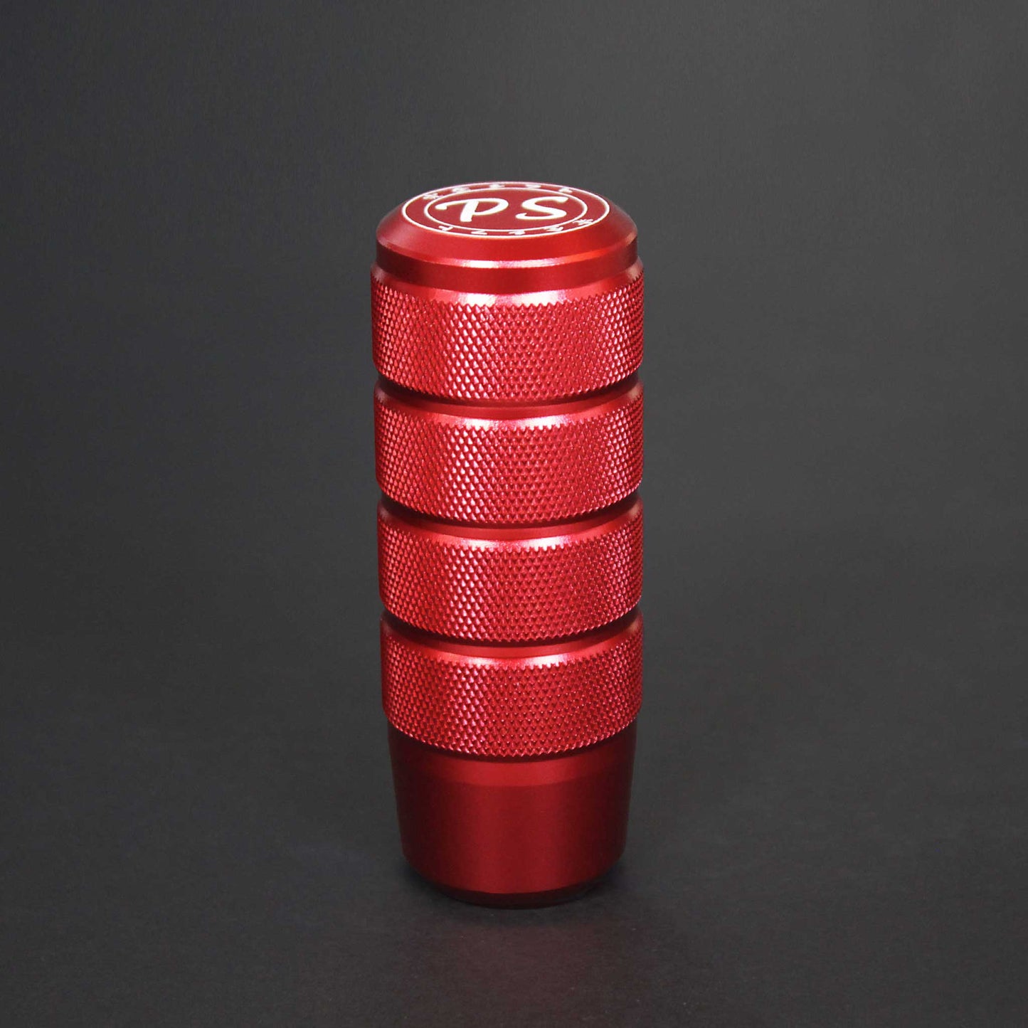 A red shift knob standing on a black background