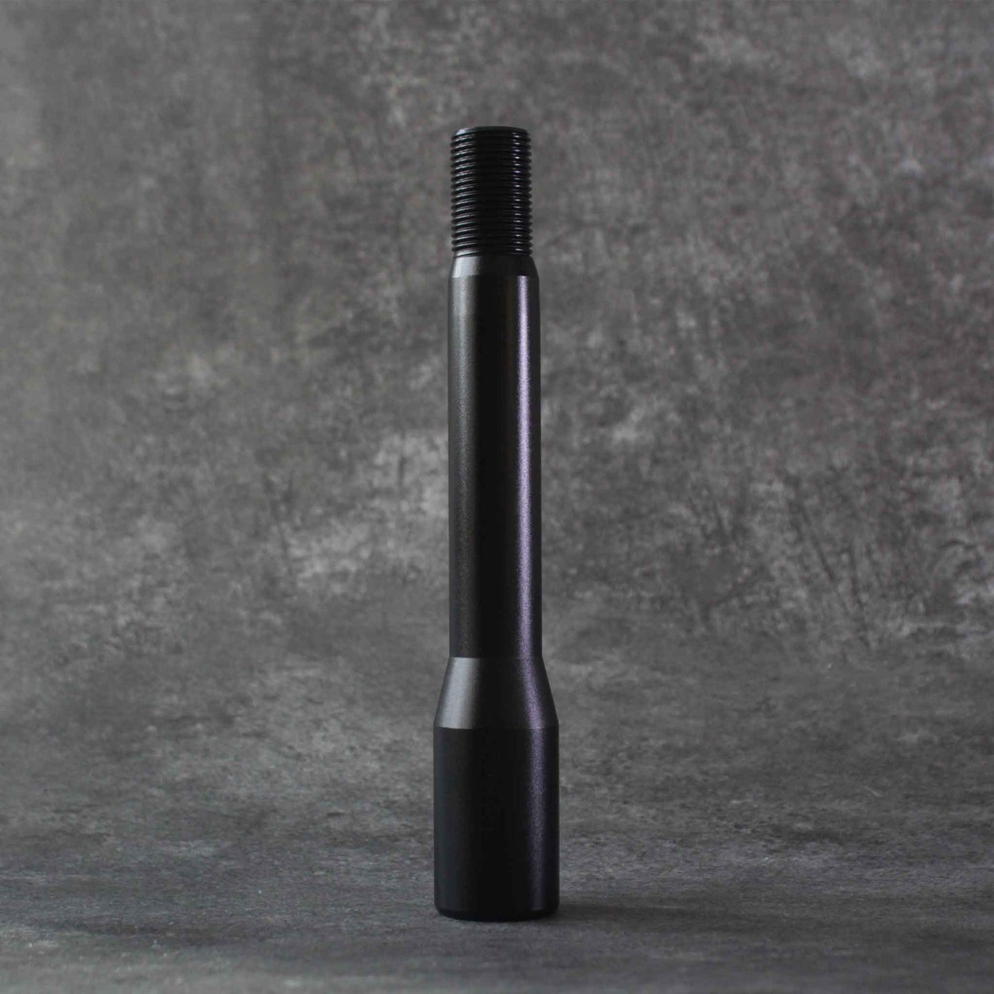 The longer extension standing on a grey floor on a grey background