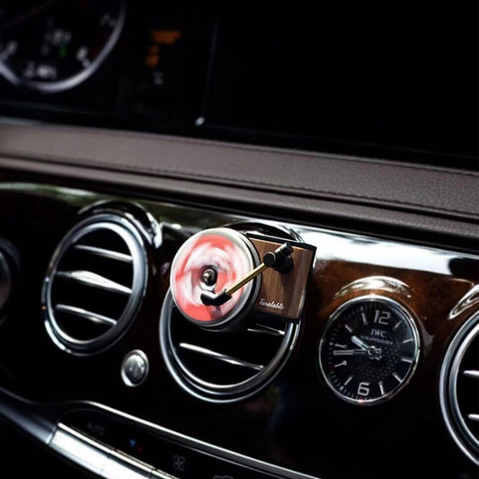 A mini record player air freshener clipped on a car's air-con vents is spinning fast