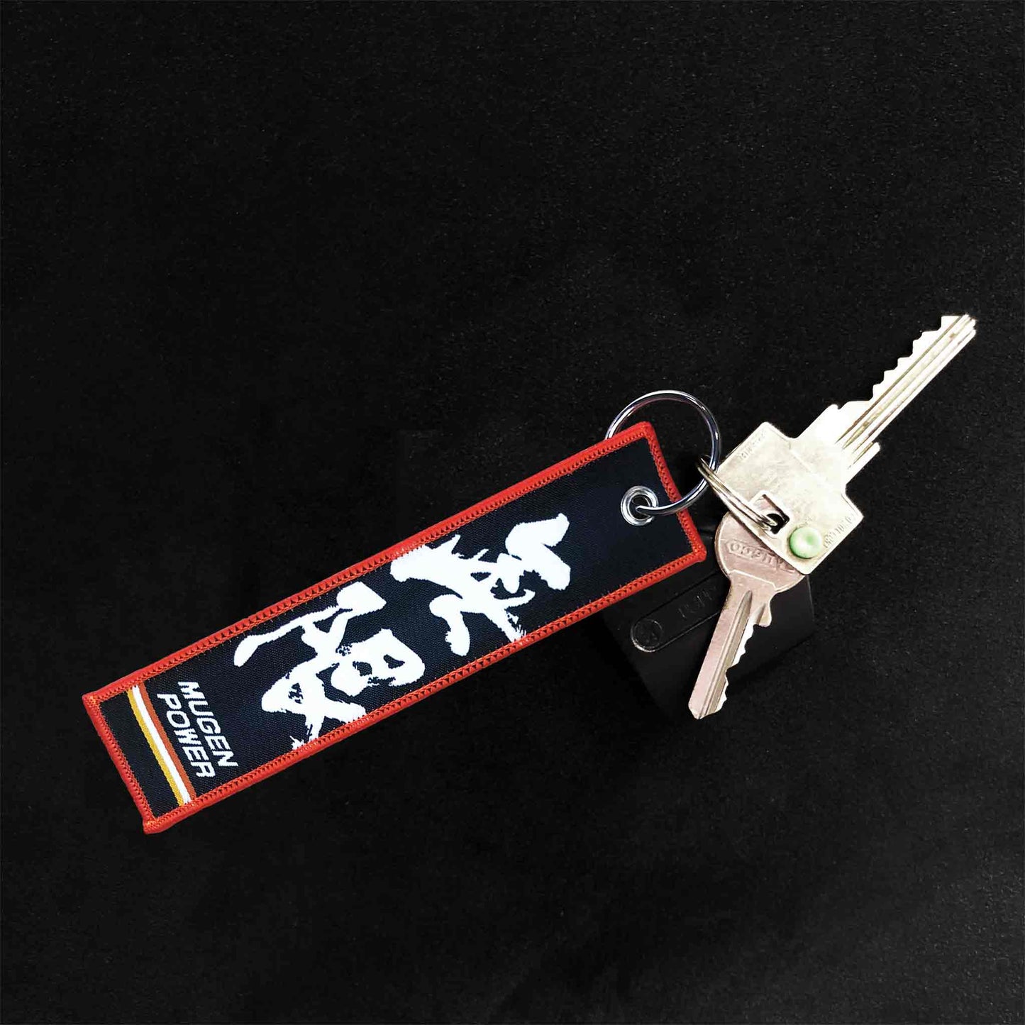 A Mugen Power jet tag on a black background