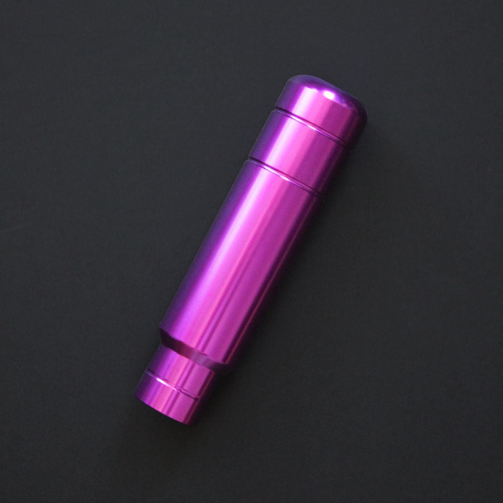 A purple aftermarket shift knob flat laid on a black background