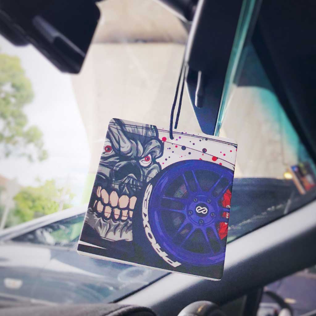 A devil JDM air freshener hung in a car