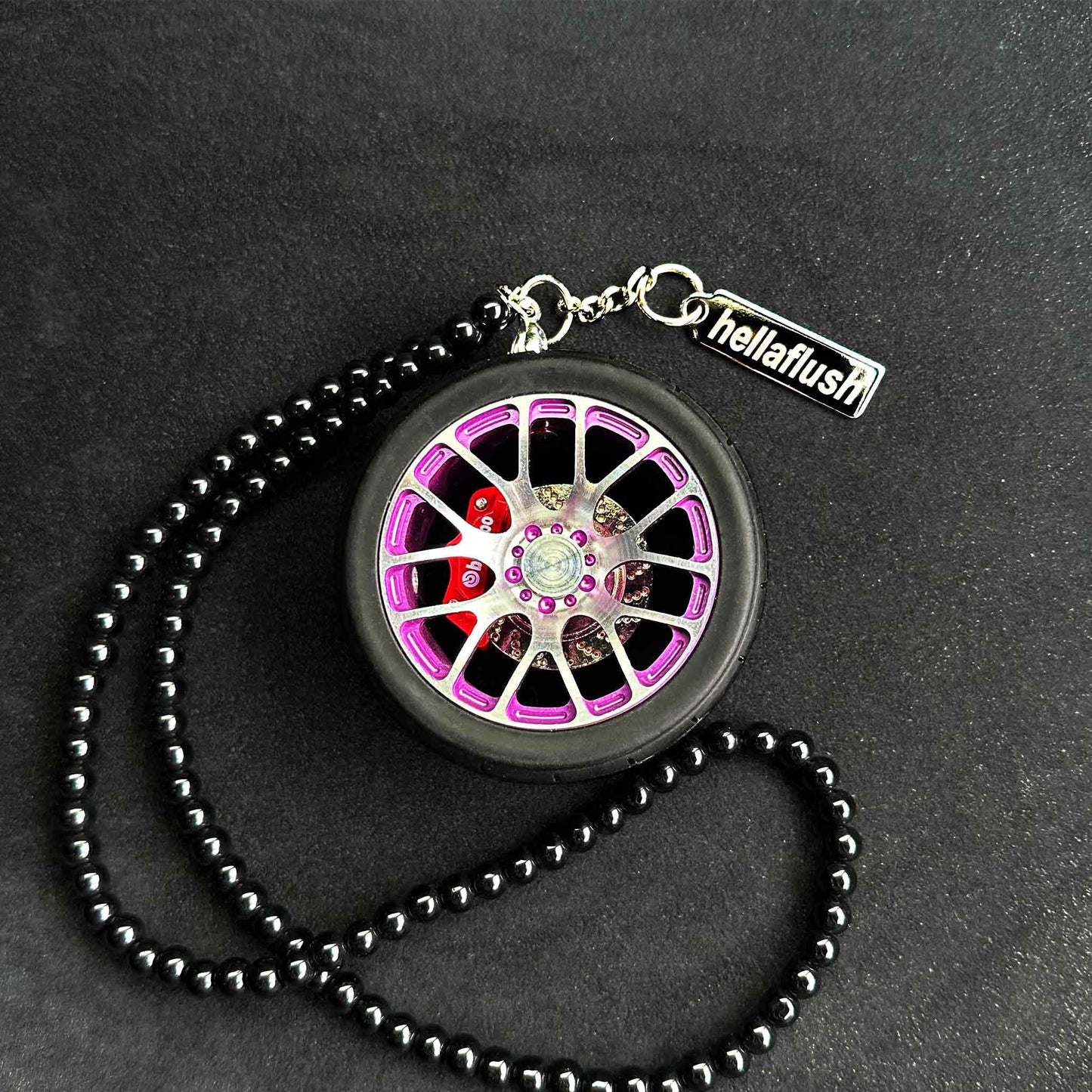A purple BBS wheel air-freshener placed on a black background