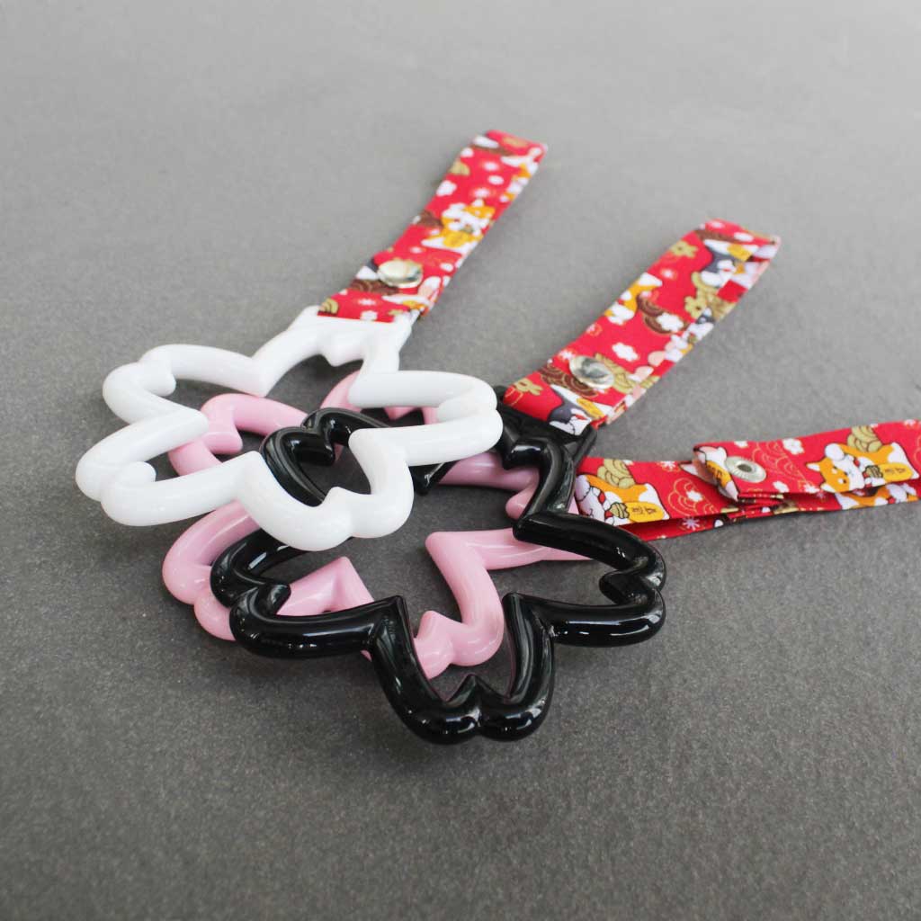 Some sakura Tsurikawas with maneki-shiba strap stacked on a concrete floor