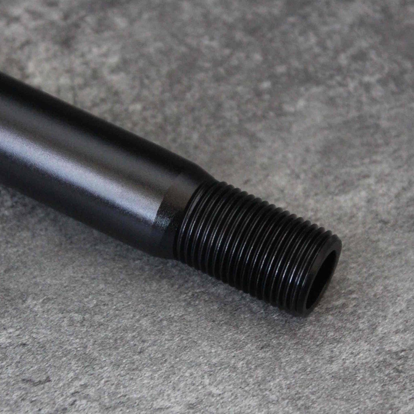 Close-up of the extension's threaded head section on a grey background