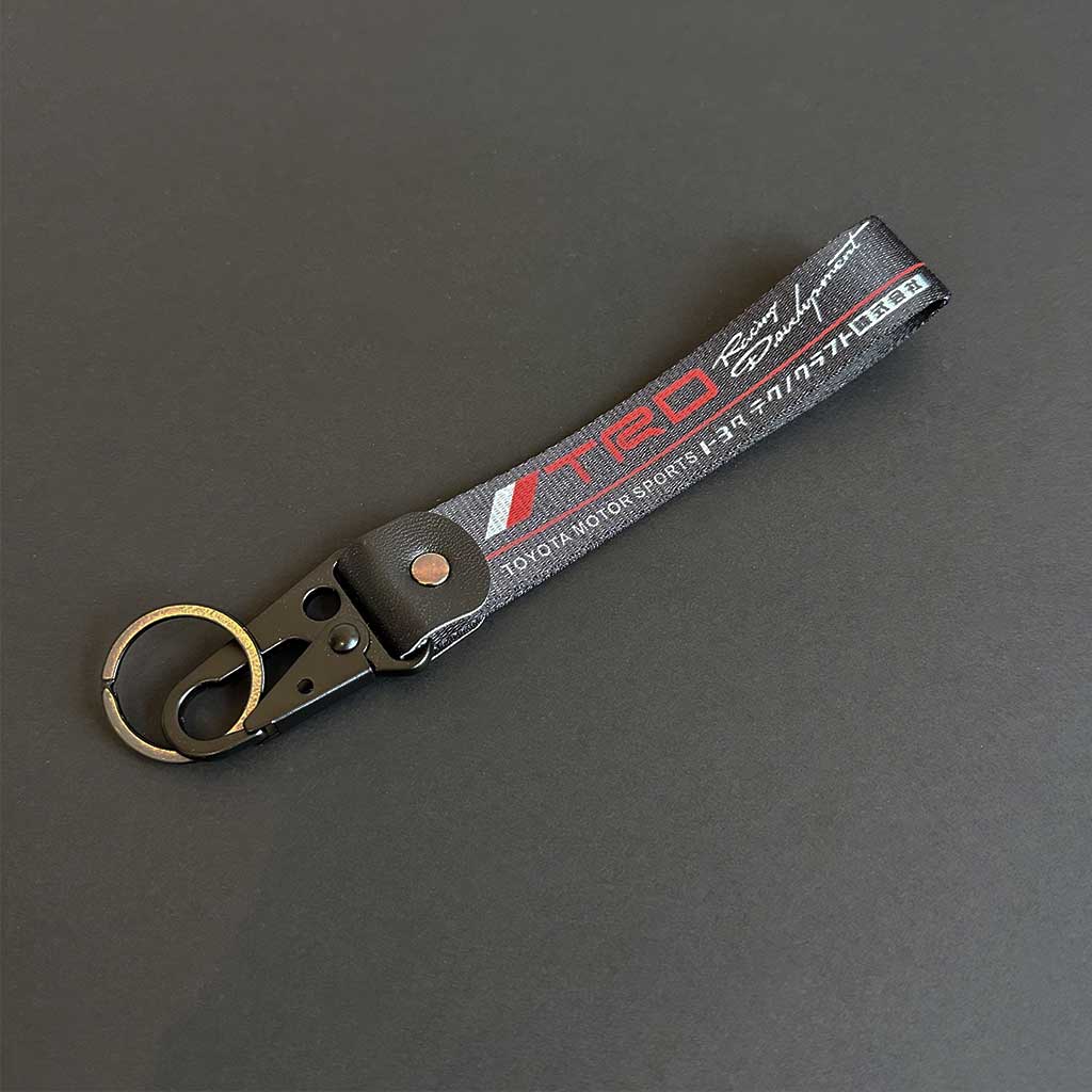 A Toyota TRD keychain flat laid on a black background