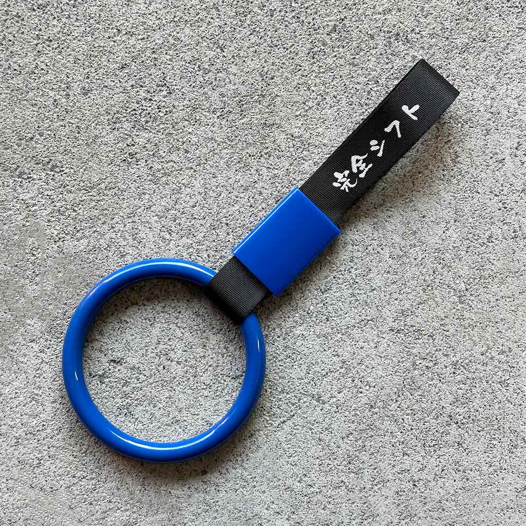 A blue ring Tsurikawa with black strap placed on a concrete ground