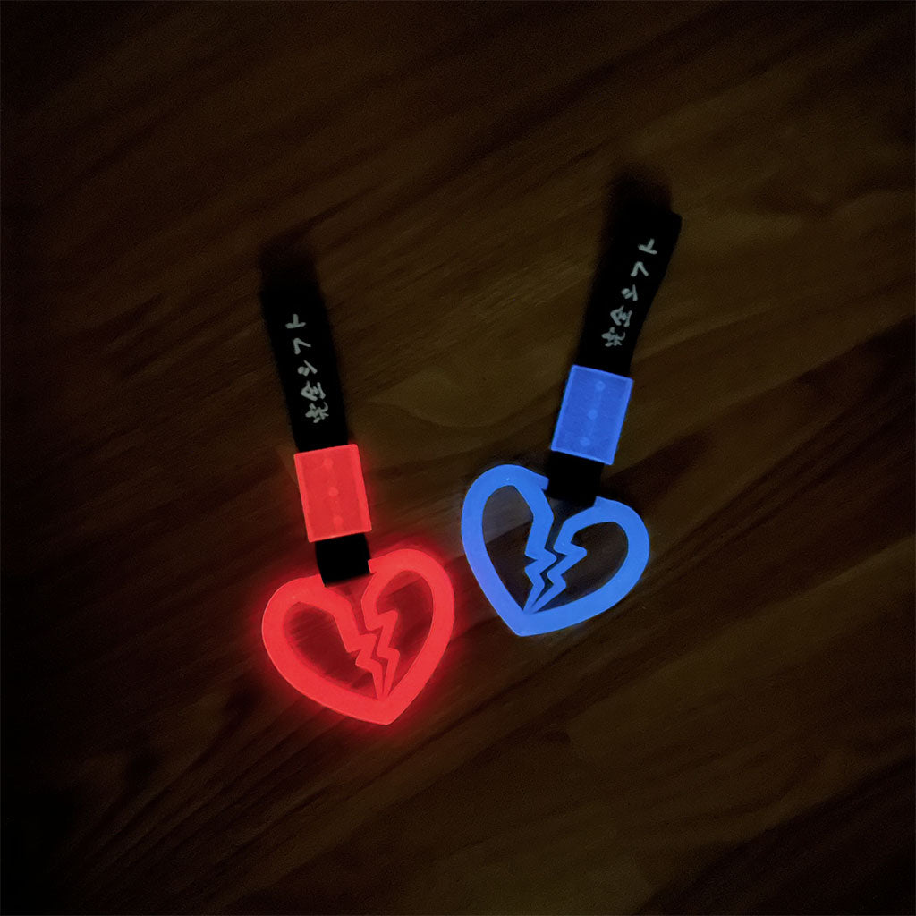 Broken heart tsurikawa flat laid on the floor in a dark room and glow blue and red
