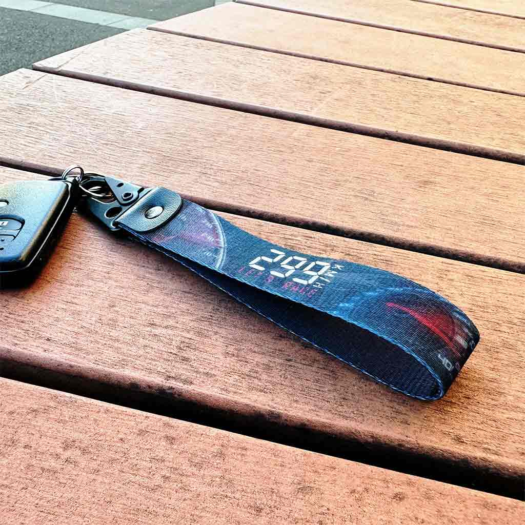 A 299km/h JDM lanyard on a wooden bench