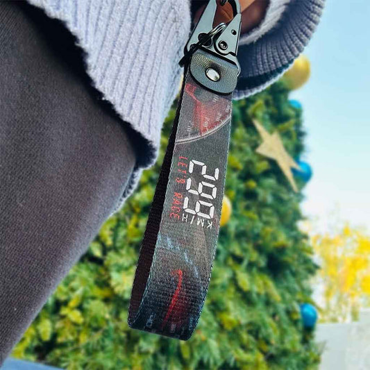 Overlooking a lanyard with the writing "299km/h Let's race" that is held by someone wearing blue knitwear and black pants