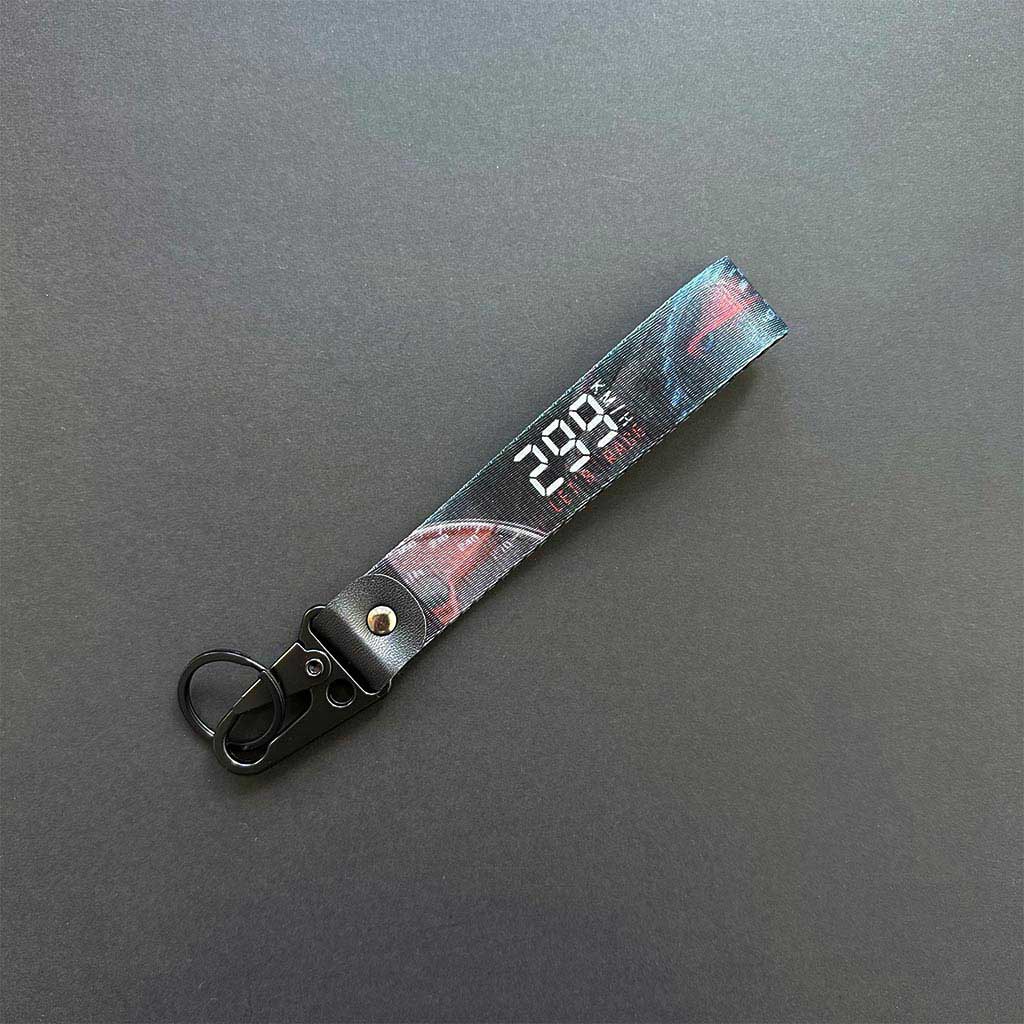 A flat lay 299km/h lanyard on a black background