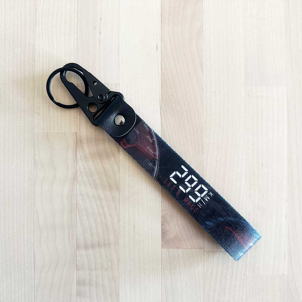 A flat lay 299km/h lanyard on a wooden table