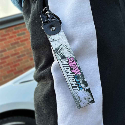 A Wangan expressway-themed lanyard in a pocket with a white Toyota 86 in the background