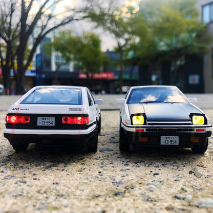 Front and back of AE86 car model with lights on in an open area