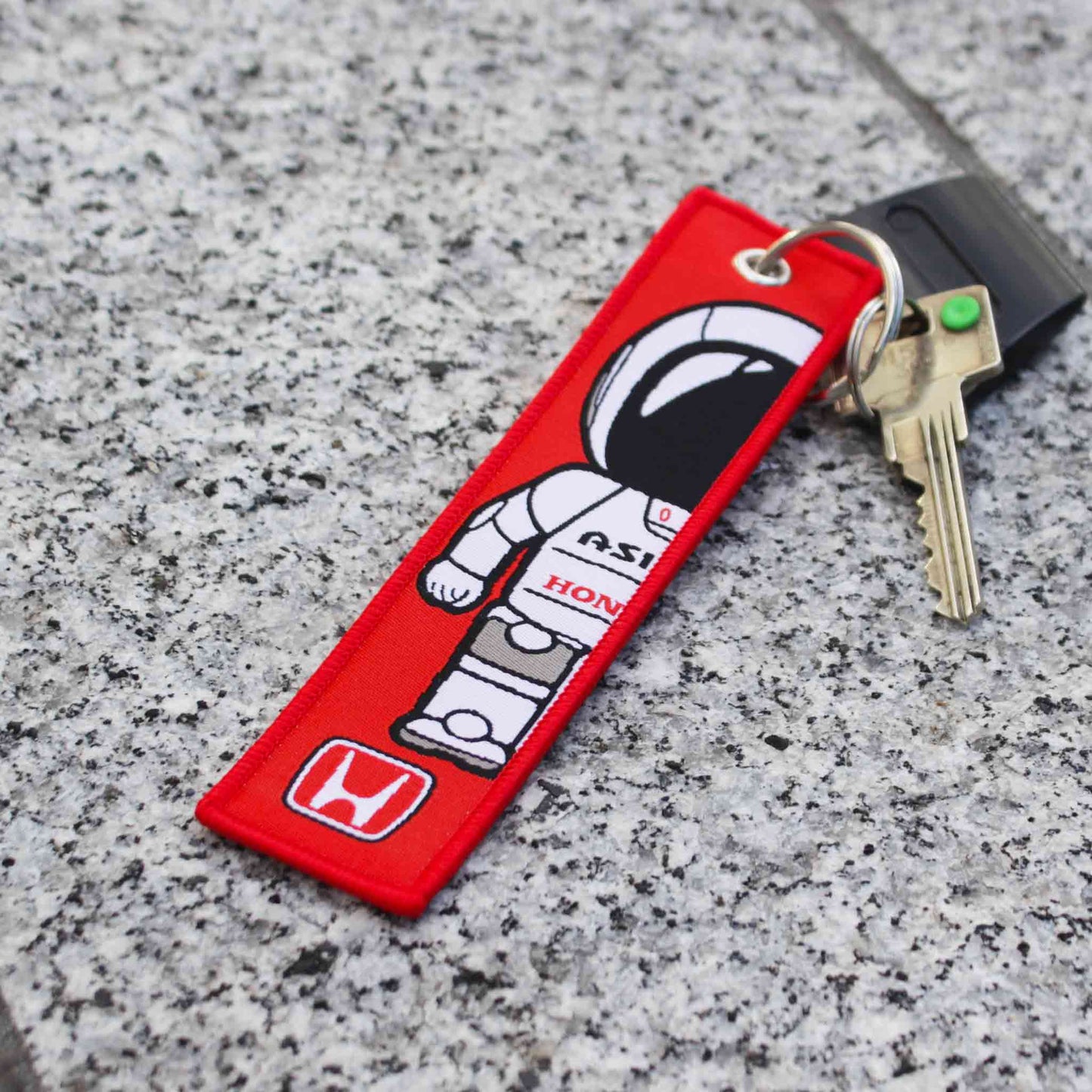 A red Honda Asimo lanyard on a marble floor