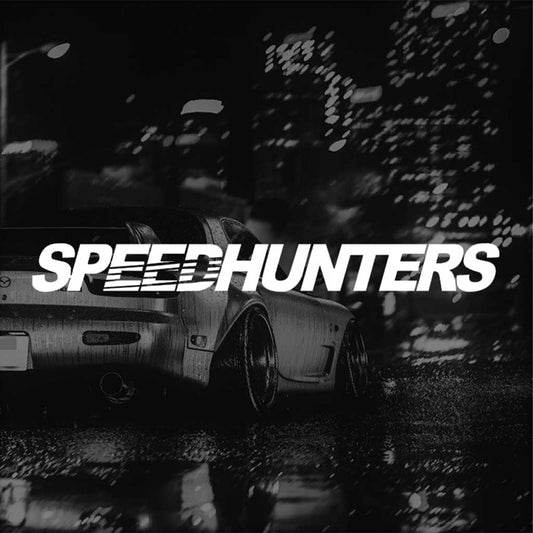 A white Speed Hunters car vinyl decal horizontally placed pointing to the screen with a darkened Mazda RX7 at the back