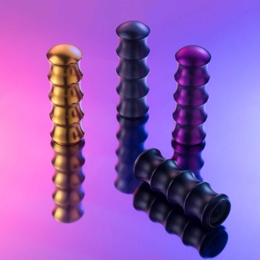 Four bamboo-shaped shift knobs in different colours placed on a reflective object, lit by neon lights