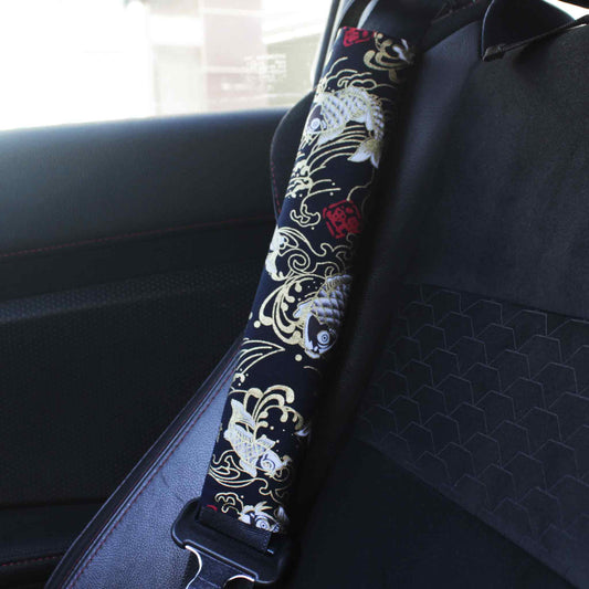 A seat belt cover with black koi fish pattern installed on a Toyota 86's seat belt
